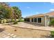Well-maintained backyard featuring a stone patio, mature trees, and a picturesque setting for outdoor relaxation at 1509 Trenton Ln, The Villages, FL 32162