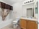 Functional bathroom features a vanity with a sink, toilet, bathtub, and a shower with a stylish curtain at 1509 Trenton Ln, The Villages, FL 32162