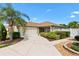 Charming exterior view of the home with lush landscaping and a long driveway leading to the garage at 1509 Trenton Ln, The Villages, FL 32162