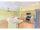 Kitchen features a bar, stainless steel appliances and wood cabinetry at 1509 Trenton Ln, The Villages, FL 32162