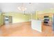 Open living room with tile flooring, chandelier lighting, and sliding glass doors to the patio at 1509 Trenton Ln, The Villages, FL 32162