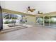 This outdoor patio features a built-in hot tub, ceiling fans, and sliding glass doors to the interior at 1509 Trenton Ln, The Villages, FL 32162