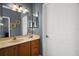 Bathroom featuring a light fixture, mirrored vanity, and a white door at 15104 County Road 48, Astatula, FL 34705