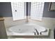 Large soaking tub with jacuzzi jets and decorative tile surround at 15104 County Road 48, Astatula, FL 34705
