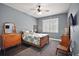 Bedroom with a window with blinds, a bed, a ceiling fan, and wooden furniture at 15104 County Road 48, Astatula, FL 34705