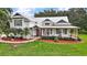 Beautiful home with a metal roof, large front yard, and a covered porch with seating at 15104 County Road 48, Astatula, FL 34705