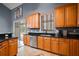 Well-equipped kitchen featuring wooden cabinets, black countertops, and stainless steel appliances at 15104 County Road 48, Astatula, FL 34705