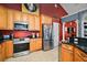 Contemporary kitchen featuring stainless steel appliances, tile floors, and wooden cabinetry at 15104 County Road 48, Astatula, FL 34705