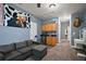 Living room featuring a grey sofa, cabinets, a mini fridge and carpeted floors at 15104 County Road 48, Astatula, FL 34705
