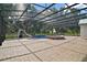 View of the pool and slide in the screened-in enclosure and brick flooring at 15104 County Road 48, Astatula, FL 34705