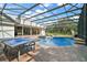 View of the pool and ping pong table in the screened-in enclosure, perfect for Gathering fun at 15104 County Road 48, Astatula, FL 34705