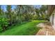 Lush green backyard with mature trees and a wooden deck area at 15925 Summit Ct, Clermont, FL 34711
