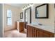 Well-lit bathroom featuring dual sinks, granite countertops, and decorative mirrors at 15925 Summit Ct, Clermont, FL 34711