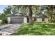 Charming single-story home with a gray garage door and lovely front lawn at 15925 Summit Ct, Clermont, FL 34711