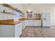 Bright kitchen with white cabinets, butcher block countertops, stainless steel appliances, and decorative shelving at 15925 Summit Ct, Clermont, FL 34711