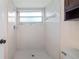 Bright shower room featuring white tiles, a window, and updated shower fixtures at 15925 Summit Ct, Clermont, FL 34711