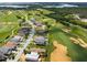 Panoramic aerial shot of a residential area bordering a golf course and lake, showcasing stunning green landscapes at 16030 Vetta Dr, Bella Collina, FL 34756