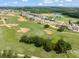 Scenic aerial view of a golf course community with lush green fairways, modern homes, and a tranquil lake at 16030 Vetta Dr, Bella Collina, FL 34756