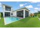 Back exterior showcasing pool, synthetic grass, and playground set creating the perfect Gathering oasis at 16030 Vetta Dr, Bella Collina, FL 34756