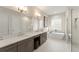 Bright bathroom with double vanity, modern lighting, soaking tub, and glass-enclosed shower at 16030 Vetta Dr, Bella Collina, FL 34756
