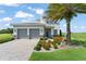 Beautiful two-story home with a gray exterior, tile roof, two-car garage, paver driveway, and mature palm tree at 16030 Vetta Dr, Bella Collina, FL 34756