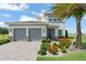 Beautiful two-story home featuring a two-car garage, lovely landscaping, and a healthy palm tree at 16030 Vetta Dr, Bella Collina, FL 34756