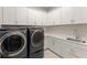 Convenient laundry room with modern washer and dryer, plus ample cabinet space at 16030 Vetta Dr, Bella Collina, FL 34756