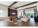 Spacious living room with wood floors, beamed ceiling, large television, and stylish furniture at 16030 Vetta Dr, Bella Collina, FL 34756