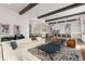 Open-concept living room featuring hardwood floors, beamed ceilings, and a modern kitchen with stainless steel appliances at 16030 Vetta Dr, Bella Collina, FL 34756