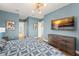 Stylish main bedroom with blue walls, modern lighting, and contemporary decor at 16030 Vetta Dr, Bella Collina, FL 34756
