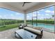 Covered patio with seating overlooking the pool and putting green, creating the perfect outdoor oasis at 16030 Vetta Dr, Bella Collina, FL 34756
