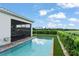 Backyard view featuring a sparkling pool, lush landscaping, and screened lanai, creating a serene retreat at 16030 Vetta Dr, Bella Collina, FL 34756