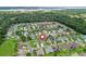 Aerial view of a residential neighborhood featuring well-maintained homes, mature trees, and proximity to a serene lake at 16863 Se 110Th Court Rd, Summerfield, FL 34491