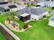 Aerial view of a home with a screened lanai, lush landscaping, and well-maintained lawn at 16863 Se 110Th Court Rd, Summerfield, FL 34491