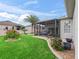 Lush backyard oasis with a screened-in lanai, vibrant landscaping, and space for outdoor enjoyment at 16863 Se 110Th Court Rd, Summerfield, FL 34491
