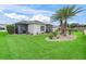 Well-maintained backyard showcasing a screened lanai, lush lawn, and attractive landscaping at 16863 Se 110Th Court Rd, Summerfield, FL 34491