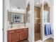 Bathroom with stylish vanity, mirror, and a walk-in shower with brown tiles and glass door at 16863 Se 110Th Court Rd, Summerfield, FL 34491