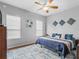 Well-lit bedroom with hardwood floors, blue accents, and two windows at 16863 Se 110Th Court Rd, Summerfield, FL 34491