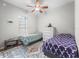 Cozy bedroom with two beds, ceiling fan and bright natural light from large window at 16863 Se 110Th Court Rd, Summerfield, FL 34491