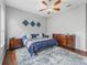 Cozy bedroom showcasing wood floors, ceiling fan, and decorative touches at 16863 Se 110Th Court Rd, Summerfield, FL 34491