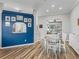 Dining room with white table and a blue wall decorated with framed pictures at 16863 Se 110Th Court Rd, Summerfield, FL 34491