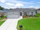 Charming one-story home with a well-manicured lawn and beautiful landscaping at 16863 Se 110Th Court Rd, Summerfield, FL 34491