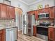 Well-equipped kitchen with stainless steel appliances, wood cabinets, and adjacent arched doorway at 16863 Se 110Th Court Rd, Summerfield, FL 34491
