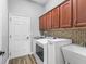 Well-equipped laundry room with washer, dryer, utility sink, and ample cabinet space at 16863 Se 110Th Court Rd, Summerfield, FL 34491