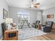 Open-concept living room with large window, shutters, and gray sofa with a ceiling fan at 16863 Se 110Th Court Rd, Summerfield, FL 34491