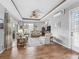 Open concept living room with wood floors, tray ceiling, ceiling fan and ample seating at 16863 Se 110Th Court Rd, Summerfield, FL 34491