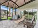 Screened patio with comfortable seating and views of the backyard, perfect for relaxing at 16863 Se 110Th Court Rd, Summerfield, FL 34491