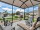Relaxing screened patio with comfortable seating, offering views of a lush backyard and tranquil surroundings at 16863 Se 110Th Court Rd, Summerfield, FL 34491