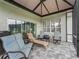 Relaxing screened patio with comfortable seating and tile flooring, perfect for outdoor entertaining at 16863 Se 110Th Court Rd, Summerfield, FL 34491