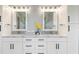 Bright bathroom featuring dual sinks, white cabinetry, and modern lighting at 1702 Hidden Palms Dr, Davenport, FL 33897